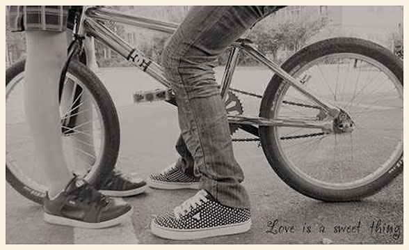 Una pareja muy joven, junto a una bicicleta.